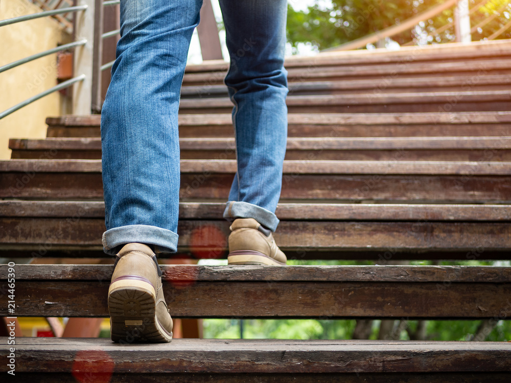 Adult man walking up the wooden stairs. Moving forward Concept. Adult man walking up the wooden stairs. Moving forward Concept.