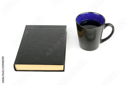 Book and cup with tea isolated on white background.