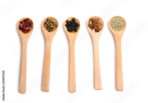 wooden spoon filled with various spices isolated on the white