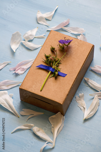 Top view of a gift box wrapped in kraft paper decorated with flower