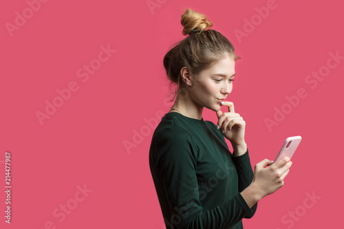 Photography Attractive hipster girl wearing hairbun, using her smartphone for reading news i