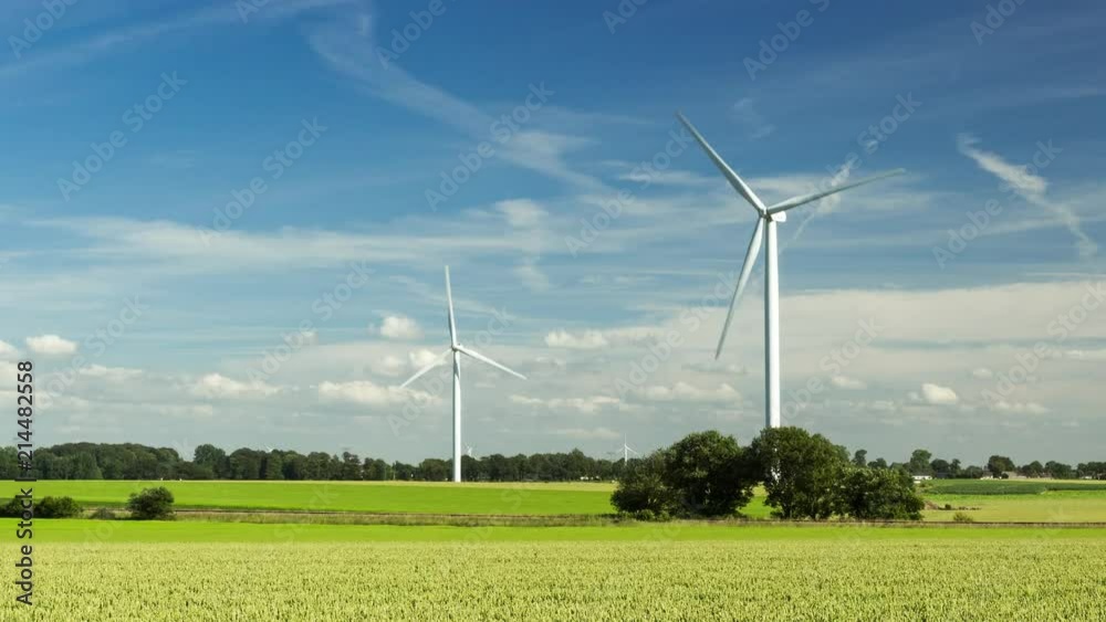 Hyperlapse of spinning wind turbines for electrical power generation with cloudy sky in Normandy, France. Modern technology of environment friendly energy production Hyperlapse of spinning wind turbines for electrical power generation with cloudy sky in Normandy, France. Modern technology of environment friendly energy production