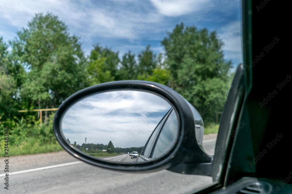 View from the car in the side rear view mirror