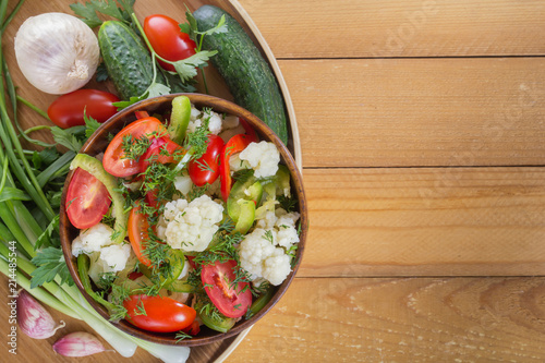 Wallpaper Mural Fresh salad of cauliflower with tomatoes, broccoli, olives, sweet pepper, herbs and vegetables in a bowl on a wooden table. Top view. Copy space. Close-up Torontodigital.ca