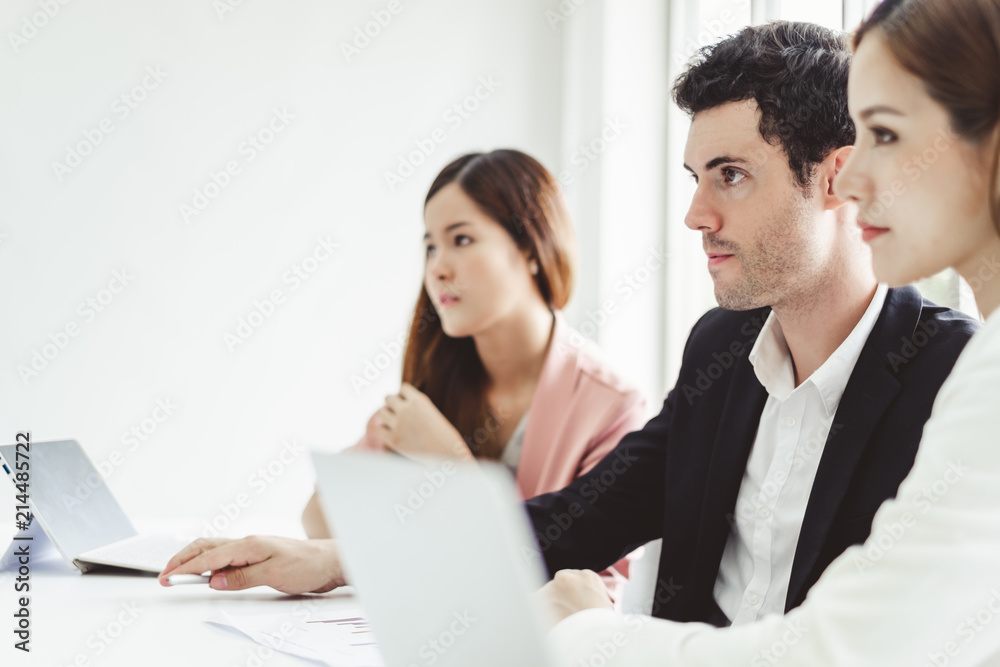 Business people concentrate discussing while meeting in office, working with laptop Business people concentrate discussing while meeting in office, working with laptop