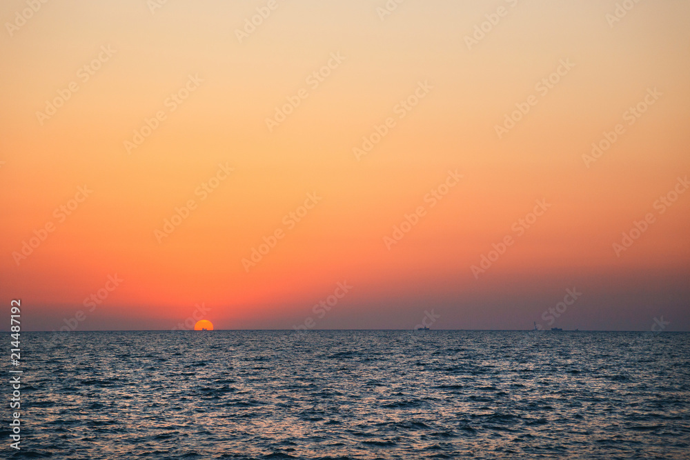 An orange blue sunrise sky, a dawn above a sea water, sunset background