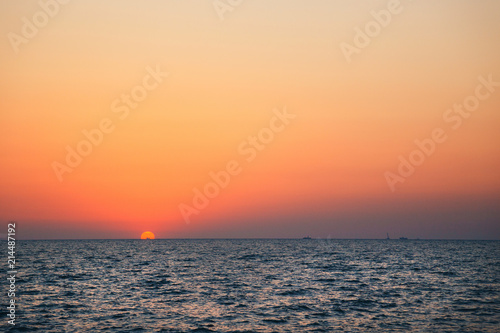 An orange blue sunrise sky, a dawn above a sea water, sunset background