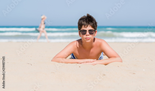 Young child on holidays at the beach with a confident expression on smart face thinking serious