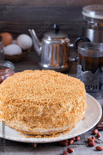 Sweet home layered honey cake on a wooden table with nuts photo