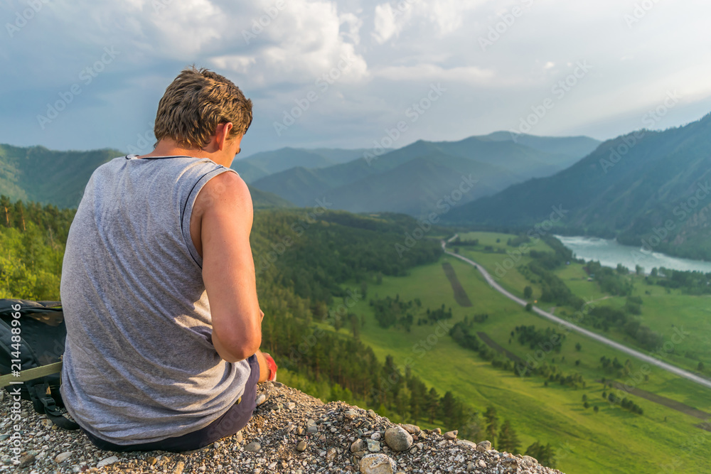 Man sitting on a mountain and staring into the distance