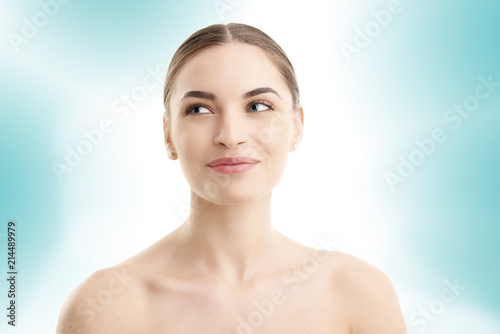 Young woman's face with radiant skin on isolated background