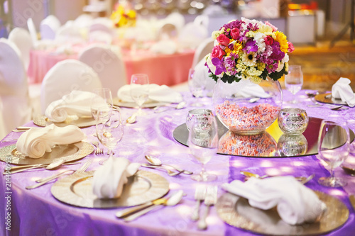 Dinner table setting with a glass vase of flower bouquet decoration