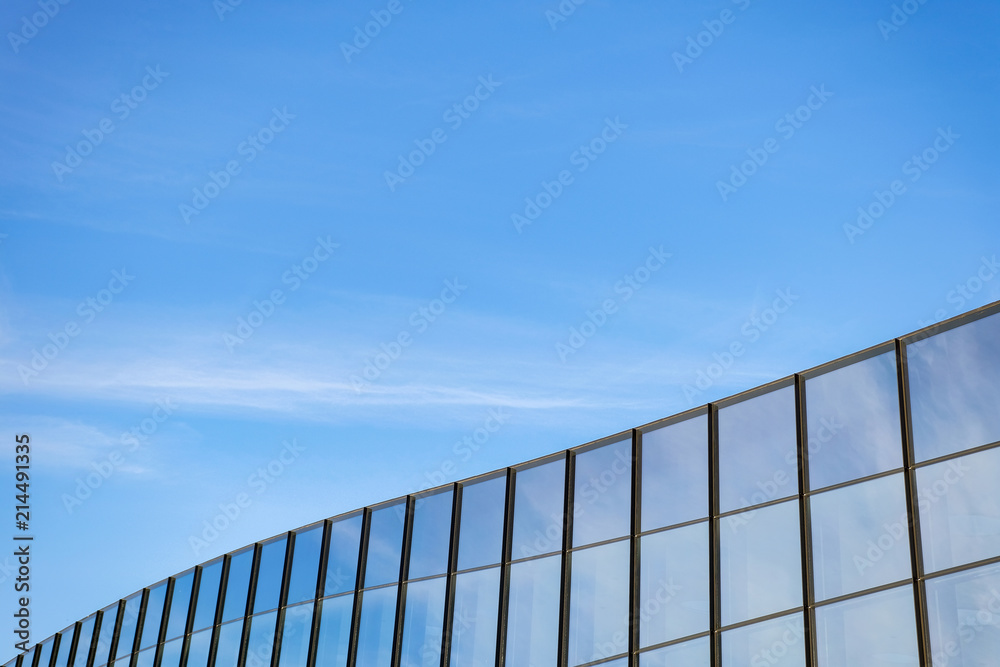 Modern building with large windows against the blue sky. Modern building with large windows against the blue sky.