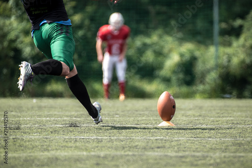 American football player kicking ball