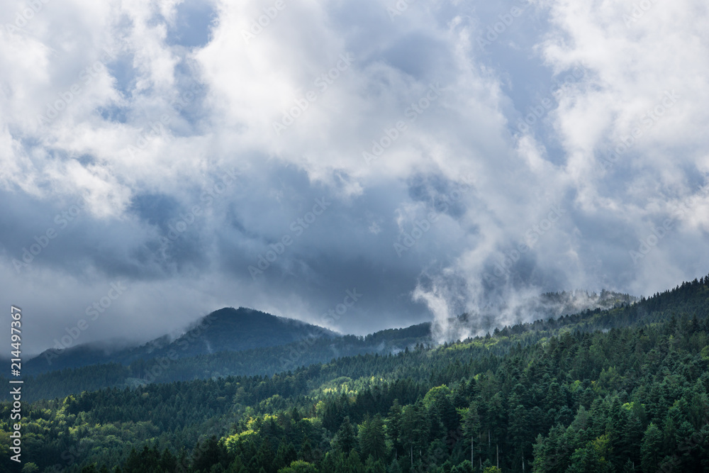Waft of mist over black forest mountains with sun and rain clouds in autumn Waft of mist over black forest mountains with sun and rain clouds in autumn