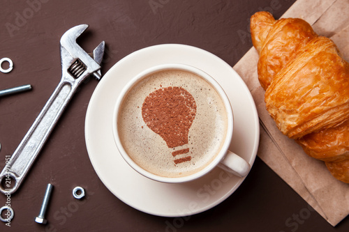 Cup of coffee with the idea symbol of a light bulb on the foam. Coffee gives new ideas and creativity