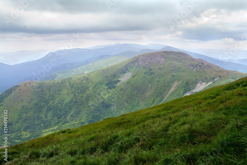 Landscape of mountains with hills and glades with cloudy sky. Carpathian mountains