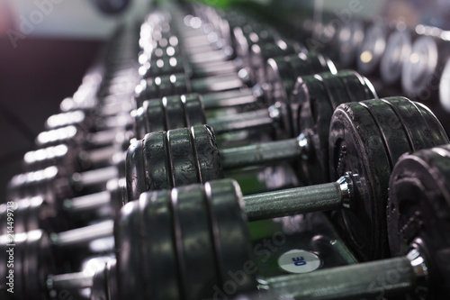 Black dumbbell set in sport fitness center. Weight Training Equipment concept. photo