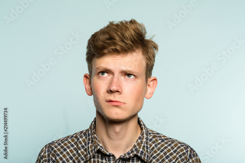 Fotografia doubtful dubious uncertain hesitant man looking up thinking over smth