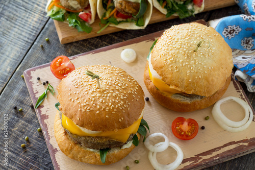 Arabic cuisine. Ramadan food. Delicious fresh homemade vegetarian mung cutlets burger and tortilla with falafel on a wooden kitchen table. Street food, fast food.