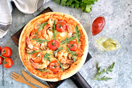 Pizza with big shrimps, cherry tomatoes, portobello mushrooms, mozzarella and arugula