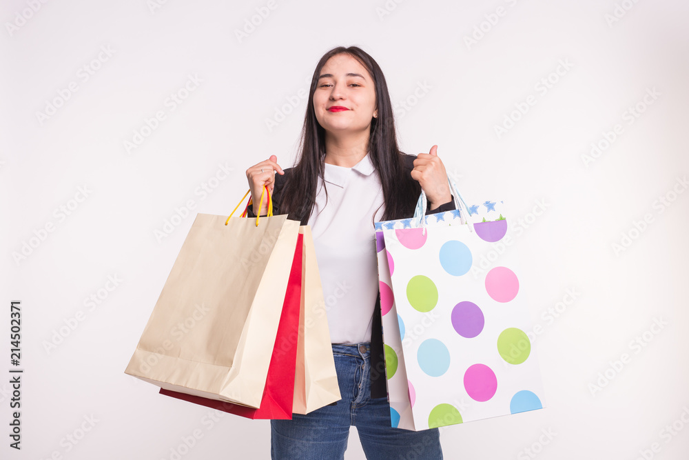 Happy asian girl with red lips holding shopping bags in light studio. Happy asian girl with red lips holding shopping bags in light studio.