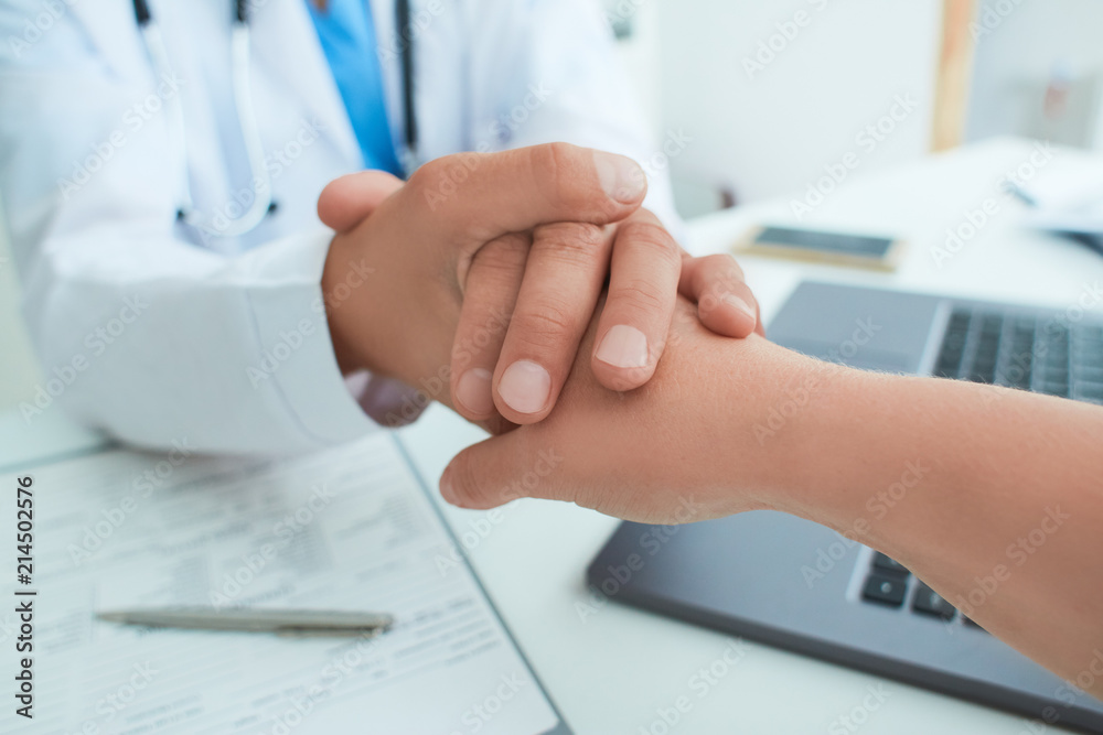 Friendly male doctor's hands holding female patient's hand for encouragement and empathy. Partnership, trust and medical ethics concept. Bad news lessening and support. Patient cheering and support Friendly male doctor's hands holding female patient's hand for encouragement and empathy. Partnership, trust and medical ethics concept. Bad news lessening and support. Patient cheering and support