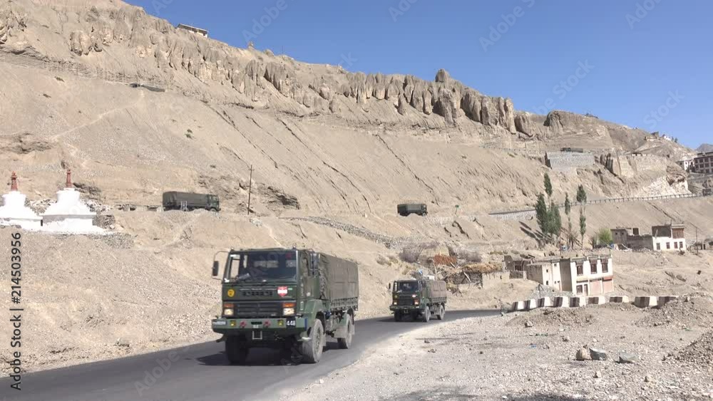 Military trucks drive on the road at Lamayuru in Leh Ladakh, Jammu and Kashmir, India Military trucks drive on the road at Lamayuru in Leh Ladakh, Jammu and Kashmir, India