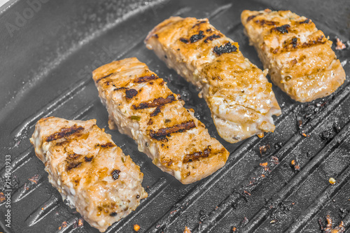 Slices of roasted salmon in a grill pan