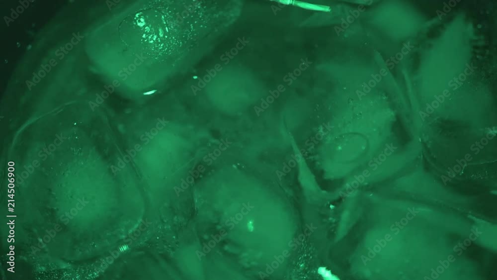 Green lights shines on ice as it melts Green lights shines on ice as it melts