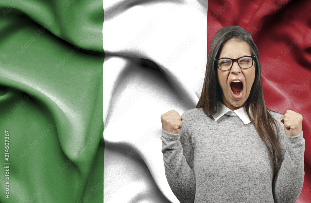 Ecstatic woman holidng fists and screaming against flag of Italy