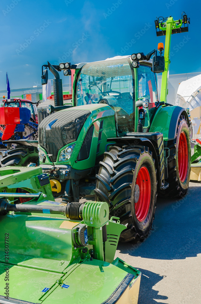 Obraz premium modern tractor for agriculture on the farm with a powerful motor, the flagship of the modern agricultural industry