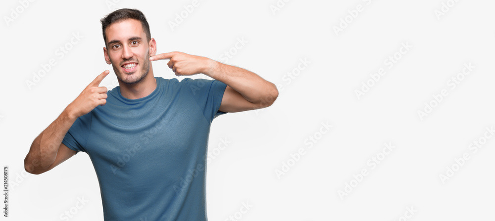 Handsome young casual man smiling confident showing and pointing with fingers teeth and mouth. Health concept. Handsome young casual man smiling confident showing and pointing with fingers teeth and mouth. Health concept.
