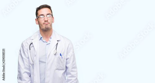 Handsome young doctor man smiling looking side and staring away thinking. © Krakenimages.com