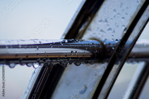 Chrome steel pipes with water drops in river port after rain.