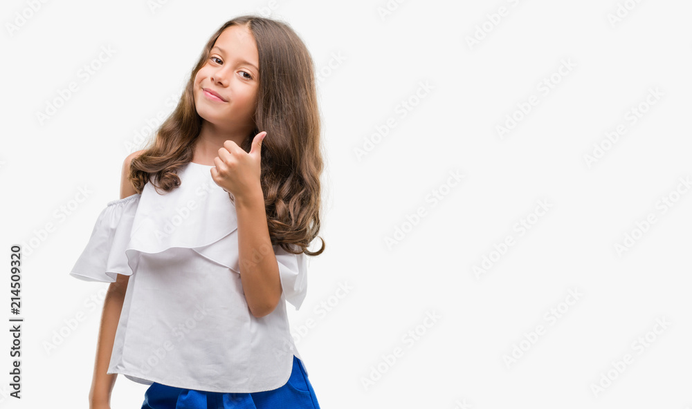 Brunette hispanic girl doing happy thumbs up gesture with hand. Approving expression looking at the camera with showing success. Brunette hispanic girl doing happy thumbs up gesture with hand. Approving expression looking at the camera with showing success.
