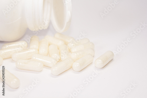 White medicine or supplement capsules on white background
