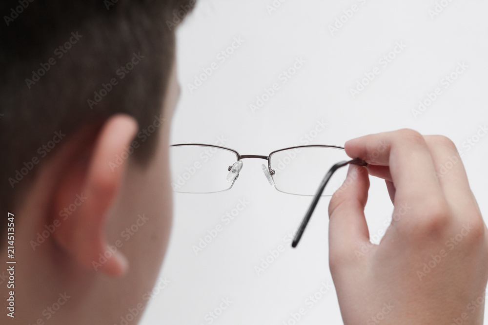 Hand with napkin wipes glasses on a white background. Hand with napkin wipes glasses on a white background.