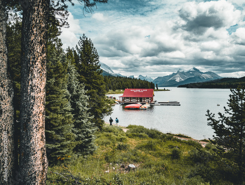 Beautiful Maligne Lake with a boathouse were you can rent canoes and snow covered mountains at the background