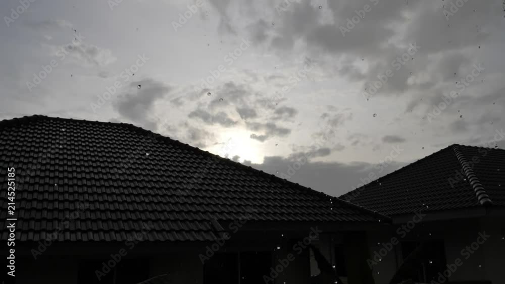 slow motion rainy day sunset scene, water pouring rain falling on roof house