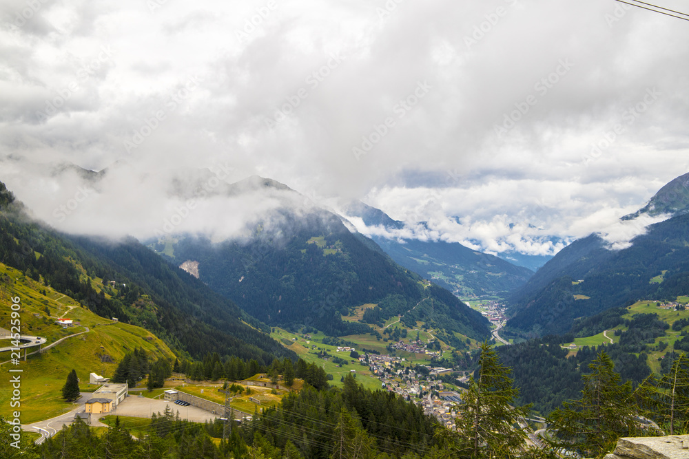 View from the top of the San Gottardo Pass to the mountain valley against the background of passing clouds