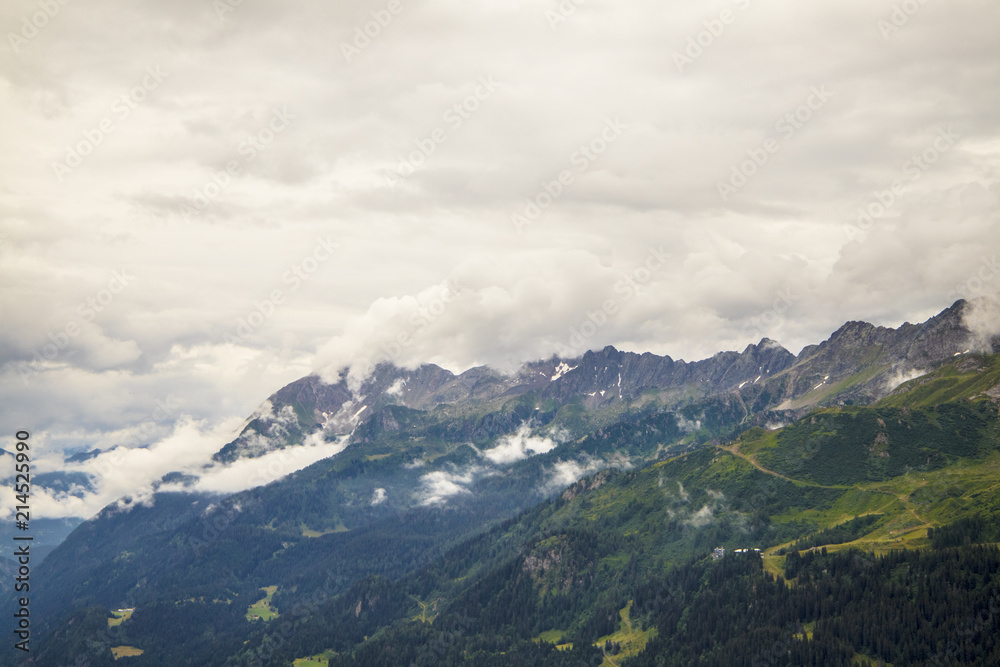 Obraz premium View from the top of the San Gottardo Pass to the mountain valley against the background of passing clouds
