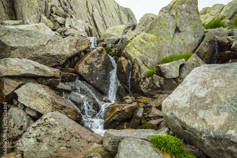 Mountain river on a background of gray mountain stones Mountain river on a background of gray mountain stones
