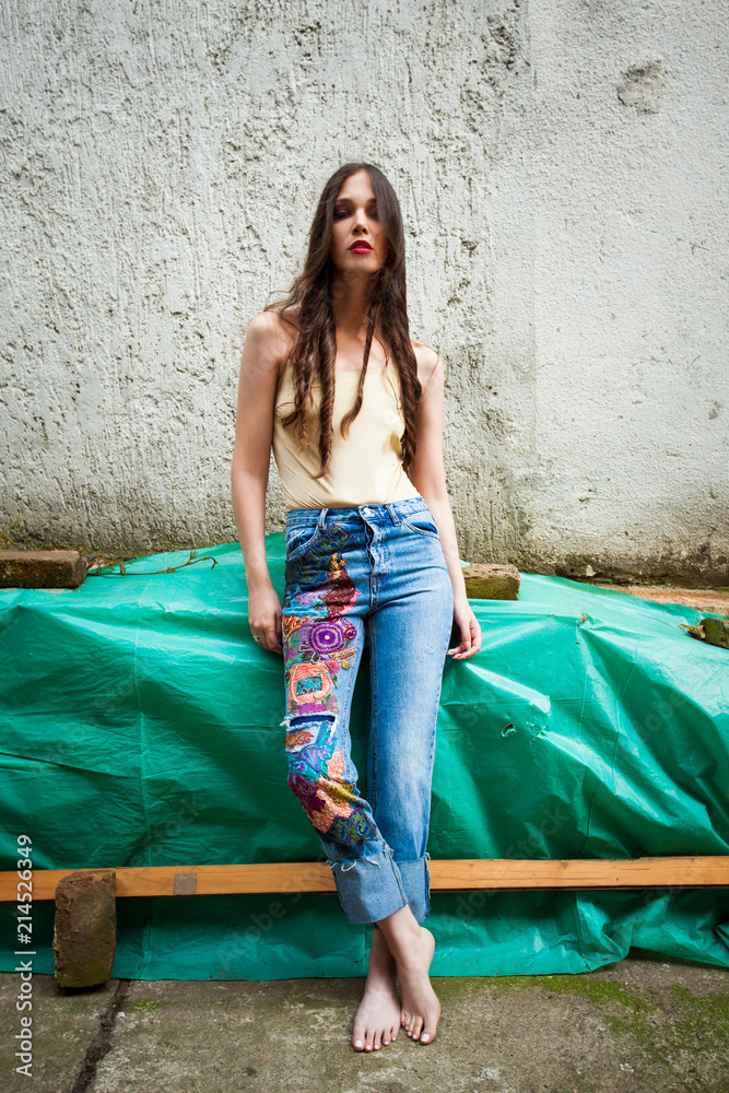 young woman in boho style blue jeans with colorful applications and and  bodysuit-nude color Stock Photo | Adobe Stock