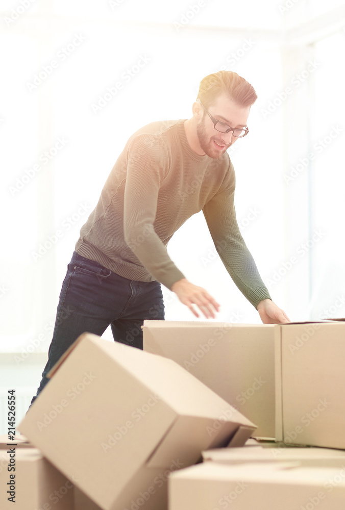 confident man unpacking boxes in the new house confident man unpacking boxes in the new house