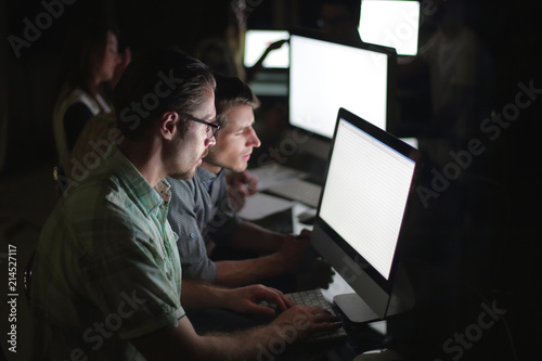 business team works on computers at night. photo