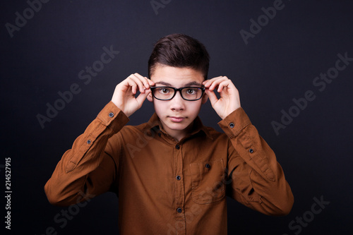 boy, the guy adjusts his glasses on a black background