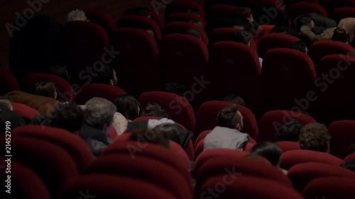 spettatori al teatro ascoltano e applaudono photo