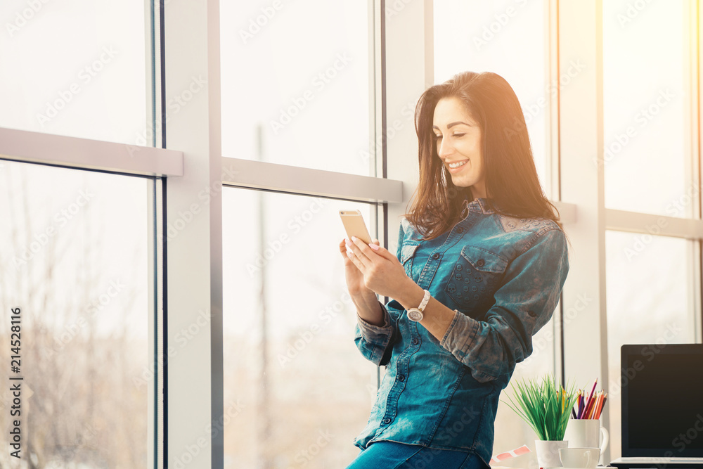 pretty designer looking woman with smartphone in office pretty designer looking woman with smartphone in office