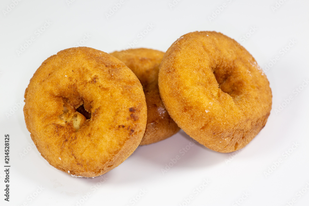 An assortment of donuts, powder donuts, chocolate donuts and plain donuts and a table waiting to be eaten An assortment of donuts, powder donuts, chocolate donuts and plain donuts and a table waiting to be eaten